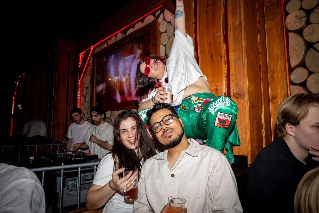 Students by the DJ booth, one sitting on shoulders