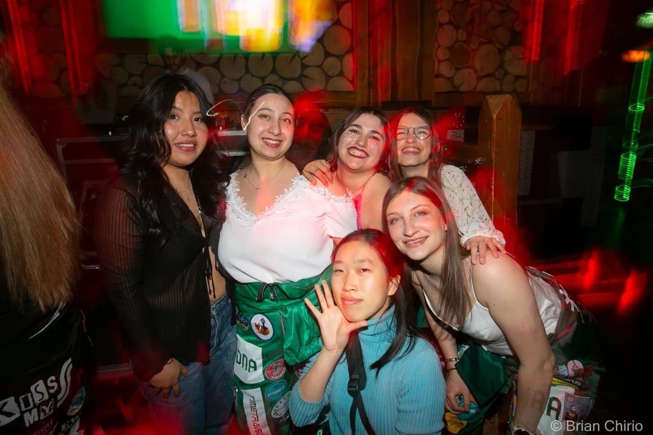 Group of six students posing together at a party